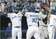  ?? TOM SZCZERBOWS­KI/GETTY IMAGES ?? The Jays’ Edwin Encarnacio­n is cheered by Jose Bautista after a three-run home run in the fourth inning.