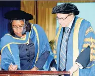  ??  ?? Dr Justice Zaila McCalla signs the Register of Honorary Graduates in the presence of University of Technology Chancellor Edward Seaga.