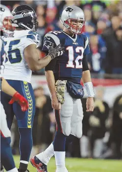  ?? STAFF PHOTO BY MATT WEST ?? TOUGH NIGHT: Tom Brady is consoled by Seahawks defensive lineman Cliff Avril after a Patriots turnover in the fourth quarter of last night’s 31-24 loss at Gillette Stadium.