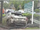  ?? STEPHEN M. DOWELL/ORLANDO SENTINEL VIA AP ?? A damaged vehicle and debris sit in front of Lake Margaret Village Apartments after a tornado struck Orlando, Fla., on Saturday night.