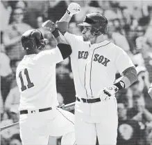  ?? ELISE AMENDOLA THE ASSOCIATED PRESS ?? Red Sox slugger J.D. Martinez celebrates his two-run home run with teammate Rafael Devers in the sixth inning at Fenway Park in Boston on Wednesday afternoon. Boston beat the Toronto Blue Jays, 6-4.