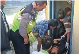  ?? EDI SUDRAJAT/JAWA POS ?? KARENA SAKIT: Petugas mengevakua­si jasad Muhariyono yang meninggal di toilet pos lantas.