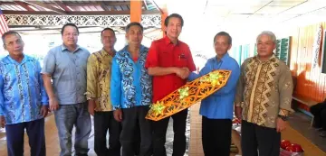  ??  ?? Dennis (third right) receives a memento from Juk Emang as other villagers look on.