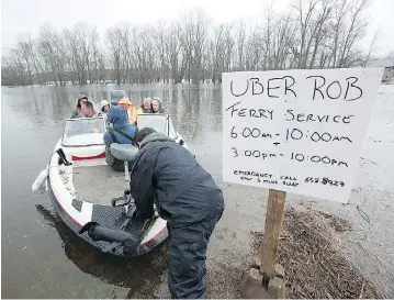  ?? ANDREW VAUGHAN / THE CANADIAN PRESS ?? Rob Dekany, known as Uber Rob, ferries stranded passengers at Darlings Island, N.B., on Thursday as the Kennebecas­is River flooded the only road into the community. Dekany has refused to accept any payment.