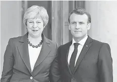  ?? — AFP photo ?? May (left) and Macron pose prior to a meeting at the Elysee Palace.