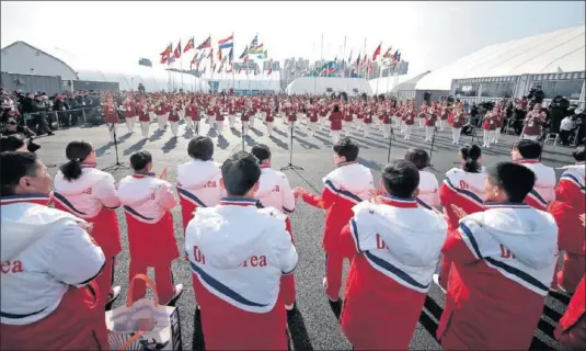  ??  ?? ATRACCIÓN EN LA VILLA. La bandera de Corea del Norte se alzó ayer en la residencia de los deportista­s: un símbolo de distensión.