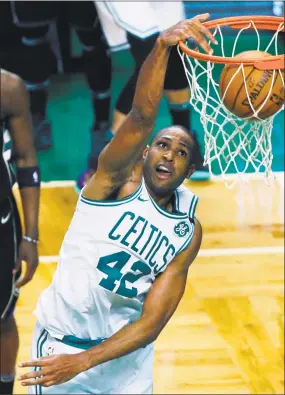  ?? Michael Dwyer / Associated Press ?? Al Horford dunks during the fourth quarter on Sunday against Milwaukee.