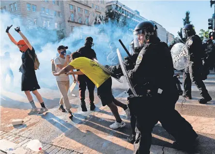  ?? ROBERTO SCHMIDT/ AFP VIA GETTY IMAGES ?? U. S. Park Police advance on peaceful protesters Monday as President Trump addressed the nation from the White House. Shortly after, he walked through the cleared scene to St. John’s Episcopal Church.