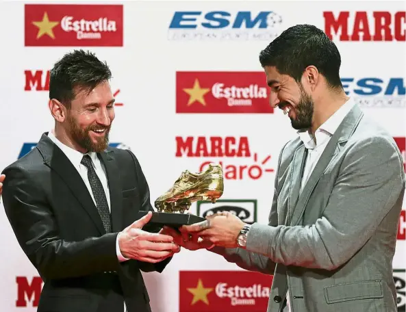  ??  ?? One of the best: Barcelona’s Lionel Messi (left) receiving his fourth Golden Boot trophy from teammate Luis Suarez during a ceremony in Barcelona on Friday. — Reuters