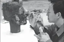  ?? PHOTOS BY ZHANG TIANZHU / FOR CHINA DAILY ?? Top: Lan Desheng (right) and his colleague Wang Dongfeng restore a Terracotta Warrior. Center: Ma Yu repairs a bronze swan unearthed in Xi’an. Above: Lan Desheng paints a warrior’s head.