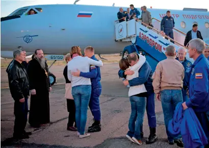  ?? AFP ?? expedition 57 Flight engineer Alexey Ovchinin of Roscosmos, and Flight engineer Nick Hague of Nasa, embrace their families after landing at the Krayniy Airport on Thursday in Baikonur, Kazakhstan. Hague and Ovchinin arrived from Zhezkazgan after Russian Search and Rescue teams brought them from the Soyuz landing site. —