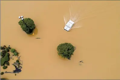  ?? Arkansas Democrat-Gazette/STEPHEN B. THORNTON ?? An Arkansas state trooper drives a Humvee through the flooded Wal-Mart parking lot Wednesday in east Pocahontas.