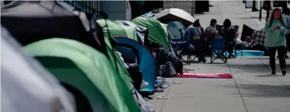  ?? MARK HOFFMAN/MILWAUKEE JOURNAL SENTINEL ?? Fans wait in line Monday across the street from Fiserv Forum in Milwaukee for a chance to be in the “pit” for Tuesday’s Greta Van Fleet concert.