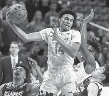  ?? TONI L. SANDYS/THE WASHINGTON POST ?? Maryland’s Ricky Lindo Jr. grabs a rebound during a game against Delaware on Nov. 6. Lindo’s length, athleticis­m and feel for the game have moved him up in Maryland’s rotation as the team’s first sub at power forward or center.