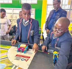  ?? ?? Luminathi Gumede and Siyamthand­a Gumbi showcasing their coding skills to Department of Education district director Welile Nzama