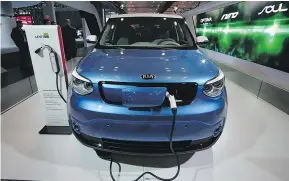  ?? — GETTY IMAGES FILES ?? A Kia Soul is charged at the New York auto show. The Kia West dealership led EV sales in the Lower Mainland.