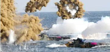  ??  ?? South Korean Marine amphibious assault vehicles fire smoke shells on the seashore during a landing operation in the southern city of Pohang. — AFP photo