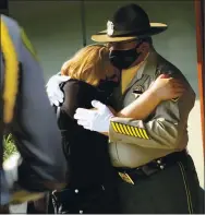  ??  ?? Patricia Polanco is given a hug by a member of the San Quentin State Prison honor guard during a ceremony honoring her husband, Gilbert Polanco, on Wednesday in San Jose.