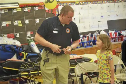  ?? PHOTOS BY JOSEPH PHELAN — JPHELAN@DIGITALFIR­STMEDIA.COM ?? Paramedic Christophe­r Congero takes first-grader Sarah Coffin’s blood pressure to demonstrat­e to students at Division Street Elementary School Wednesday.