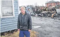  ?? KEVIN ADSHADE/THE NEWS ?? Kimo Poirier stands by his house on Creighton Street in Pictou, near the rubble after a fire destroyed a building on March 19.