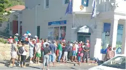  ??  ?? CAN’T WAIT: People queue up outside the bottle store in Kalk Bay’s Main Road while waiting for it to open. The store is across the road from the beach.