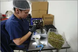  ?? PAUL SANCYA — THE ASSOCIATED PRESS ?? Jessica Owl weighs True North Collective recreation­al marijuana during packaging in Jackson, Mich., Wednesday.