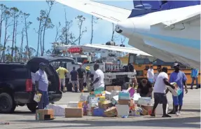  ?? TREVOR HUGHES/USA TODAY ?? People unload humanitari­an aid at the airport on Treasure Cay in the Bahamas following the passage of Hurricane Dorian on Saturday.