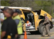  ?? (AP/Austin American-Statesman/Jay Janner) ?? A Texas Department of Public Safety trooper inspects the scene of a fatal school bus crash on Texas State Highway 21 near Caldwell Road on Friday in Bastrop, Texas.