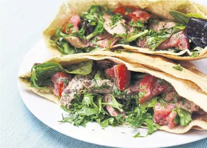  ?? KARON LIU/TORONTO STAR ?? Get your grill on with these steak pitas stuffed with greens, fresh mint, tomatoes and a spicy honey and Greek yogurt dressing.