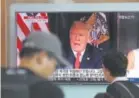  ?? Lee Jin-man, Associated Press file ?? South Koreans walk past a TV screen showing a news report about President Donald Trump threatenin­g North Korea “with fire and fury like the world has never seen” on Aug. 9 in Seoul.