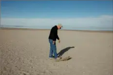  ?? ?? Kevin Perry, a professor of atmospheri­c studies at the University of Utah, walks on land that used to be submerged by the Great Salt Lake on March 15.