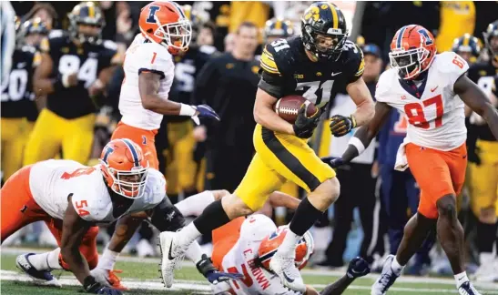  ?? CHARLIE NEIBERGALL/AP ?? Iowa linebacker Jack Campbell leaves Illinois defenders in his wake while returning an intercepti­on for a touchdown to seal the Hawkeyes’ victory Saturday.