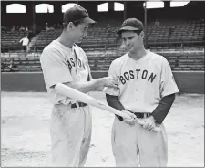  ?? AP FILE PHOTO ?? In this May 14, 1942 photo, Red Sox left fielder Ted Williams, left, tests the arm of second baseman Bobby Doerr before a game in Chicago.