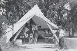  ??  ?? Campers making their beds and cleaning their tent at Bolton Camp in the ’60s.