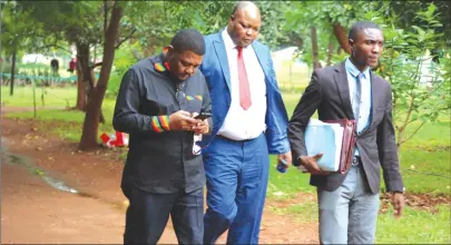  ?? Picture by Lee Maidza ?? Former Foreign Affairs Minister Walter Mzembi (left) arrives at the Harare Magistrate­s’ Courts in the company of his lawyer Mr Job Sikhala (centre) in Harare yesterday.