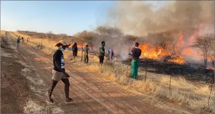  ?? Photos: Contribute­d ?? Battle… A team fights the weekend veld fire that has ravaged part of Outjo and Kamanjab farmer Mike Kavekotora’s farm.