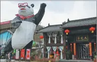  ??  ?? A street in Fanhuali commercial town, Baiyun district in Guiyang, features a giant panda statue and a more than 380-year-old traditiona­l house.