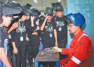  ??  ?? TARIK MINAT: Para peserta program diberi penerangan oleh salah seorang tenaga pengajar di Politeknik Kuching Sarawak tentang latihan dalam bidang kimpalan.