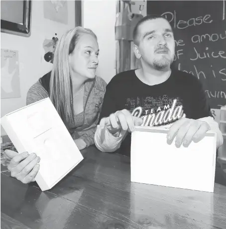  ?? NICK BRANCACCIO ?? Noah Helou holds an empty iPad box along with his support worker, Kristina Clark, on Tuesday in Helou’s Windsor home. Helou uses his specialize­d iPad to communicat­e but the device was stolen from his mother’s car while he was being helped into their...