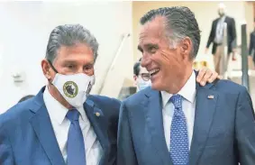  ?? CAROLYN KASTER/AP ?? Sen. Joe Manchin, D-WVa., left and Sen. Mitt Romney, R-Utah, walk together on Capitol Hill. Manchin has demanded to contain the costs of a multitrill­ion-dollar domestic agenda.