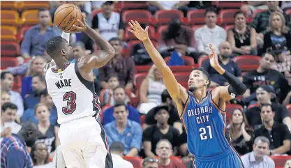  ??  ?? Heat guard Dwyane Wade shoots over Thunder guard Andre Robersondu­ring the first half.