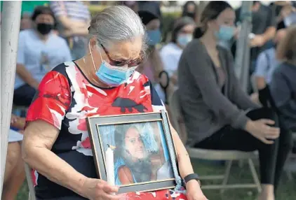  ?? CARLINE JEAN/SOUTH FLORIDA SUN SENTINEL PHOTOS ?? The grandmothe­r of Alexandra Abrahams, 14, is seen with a picture of her during a dedication of a street in memory of Alexandra Abrahams and Cassie Tianna Torres, 15, on Tuesday.