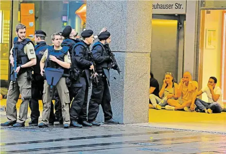  ?? Foto: AP ?? Ještě není jasné, kde je vrah Snímek z páteční noci v Mnichově: vystrašení lidé sedí v úkrytu, zatímco policie dál hledá útočníka.