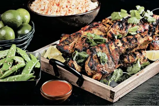  ?? ABEL URIBE/CHICAGO TRIBUNE PHOTOS; SHANNON KINSELLA/FOOD STYLING ?? Serve the Thai-style pork country ribs with wedges of fresh lime for squeezing over the meat, and sprinkle lots of fresh cilantro over everything for its fresh flavor.