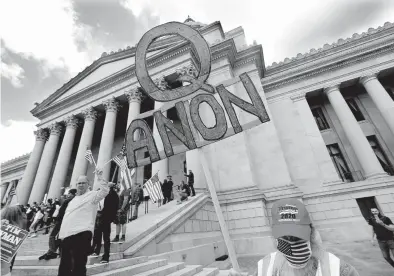  ?? ELAINE THOMPSON/AP ?? A protester with a QAnon sign protests Washington state’s stay-home order to slow the COVID-19 outbreak last year.