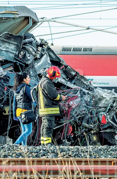  ?? (foto Ansa) ?? I rilievi Un vigile del fuoco e una poliziotta della Scientific­a davanti alla motrice distrutta del treno