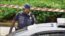  ?? WILL DICKEY / FLORIDA TIMES-UNION ?? A police officer stands outside the Jacksonvil­le Landing on Sunday after the mass shooting. Three people were killed, and 11 injured.