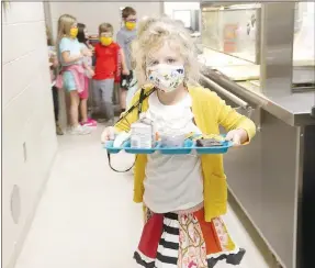  ?? LYNN KUTTER ENTERPRISE-LEADER ?? Aria Thomas, a first-grader at Prairie Grove Elementary, picks up a lunch tray for the day. Meals are free for all students through December.