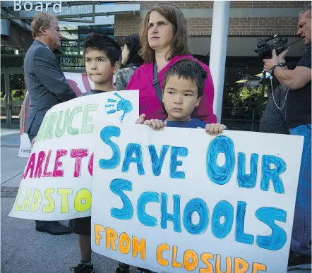  ?? MARK VAN MANEN/PNG ?? Melanie Cheng and her sons Dencell, left, and Connor, join other parents, students and politician­s in a protest Monday outside the Vancouver school board offices.