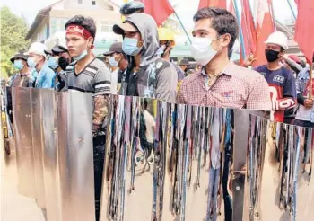  ?? DAWEI WATCH ?? Protesters hold homemade shields Saturday in Dawei, Myanmar, during a demonstrat­ion against a military coup.